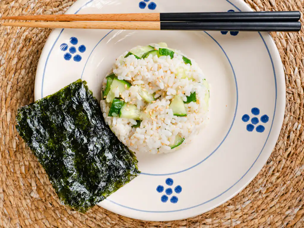 aesthetic food photography display of low calorie kimbap with green cucumber accents and roasted sesame.