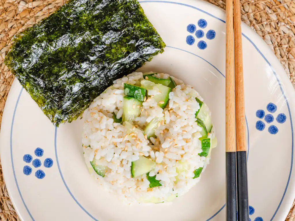A top-down shot of a Korean seaweed rice bowl served with crisp seasoned seaweed snack sheets on the side.