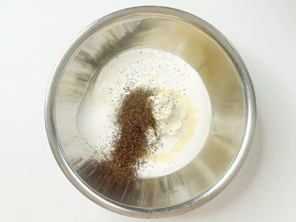 Whipping heavy cream with mascarpone cheese and Earl Grey tea leaves in a mixing bowl