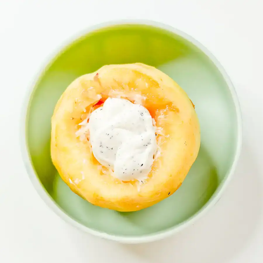 Filling the cored center of a fresh peach with Earl Grey whipped mascarpone cream.