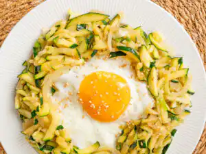Korean Zucchini Rice Bowl: Easy Aehobak Deopbap Recipe lose-up of glossy stir-fried zucchini slices cooked with garlic and oyster sauce over white rice.