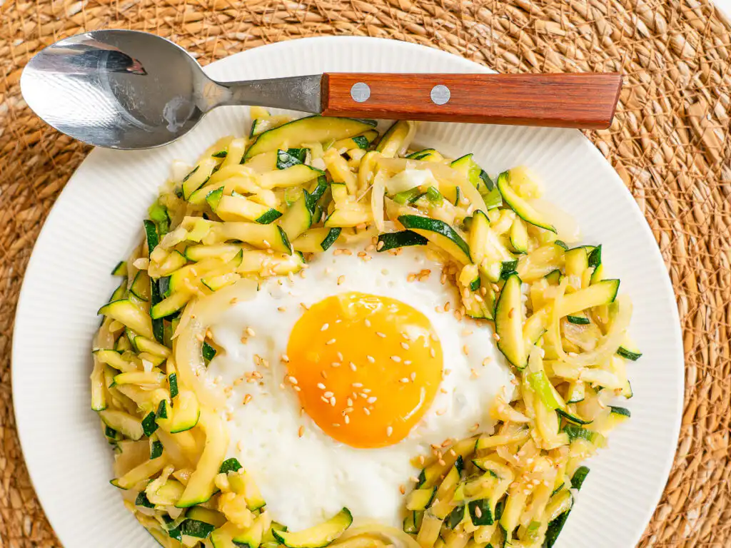 Korean Zucchini Rice Bowl: Easy Aehobak Deopbap Recipe healthy korean zucchini rice bowl served with a glistening sunny-side-up egg in a warm ceramic bowl.