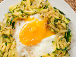 Korean Zucchini Rice Bowl: Easy Aehobak Deopbap Recipe Easy zucchini rice bowl garnished with toasted sesame seeds and chopped green onions.