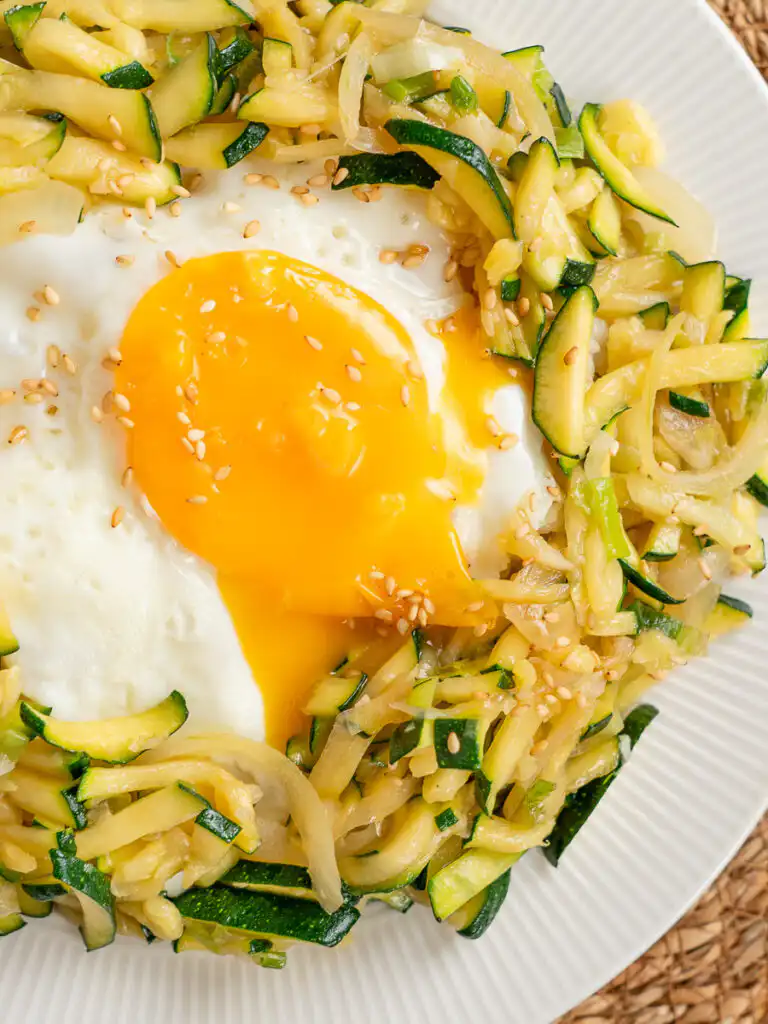 Korean Zucchini Rice Bowl: Easy Aehobak Deopbap Recipe Easy zucchini rice bowl with a runny egg yolk being mixed into the rice.