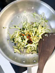 Korean Zucchini Rice Bowl: Easy Aehobak Deopbap Recipe Adding salted zucchini, tuna fish sauce, and oyster sauce to the frying pan.