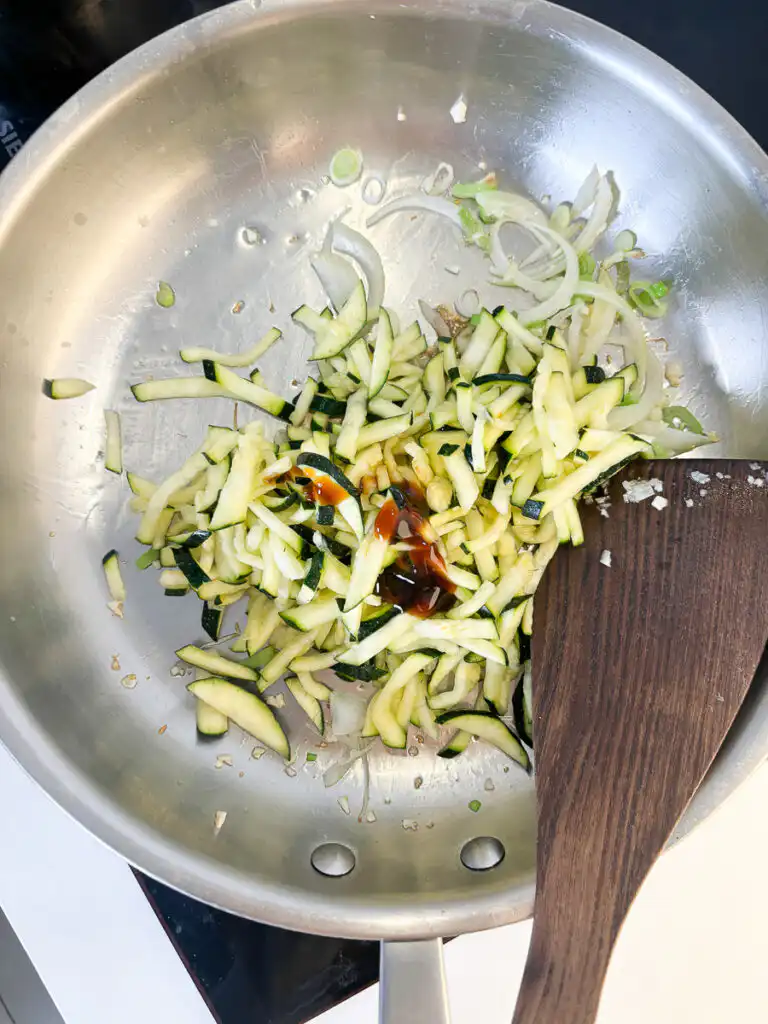 Korean Zucchini Rice Bowl: Easy Aehobak Deopbap Recipe Adding salted zucchini, tuna fish sauce, and oyster sauce to the frying pan.