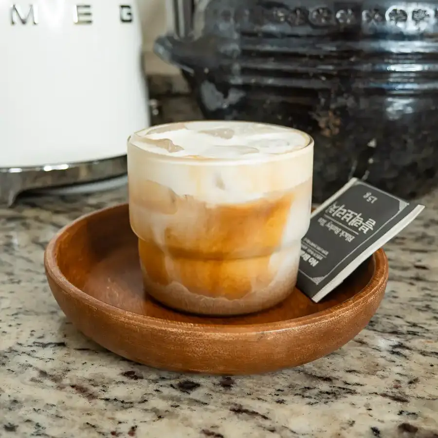 Viral Korean Barley Tea Latte: Easy Boricha Latte in 5 min Freshly stirred iced café latte with barley tea in a tall clear cup.