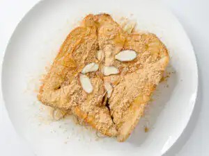 5 Min Injeolmi Toast: Easy Sulbing Toast with Korean Rice cake Sliced almond pieces sprinkled over dusting of konggaru on top of injeolmi toast.