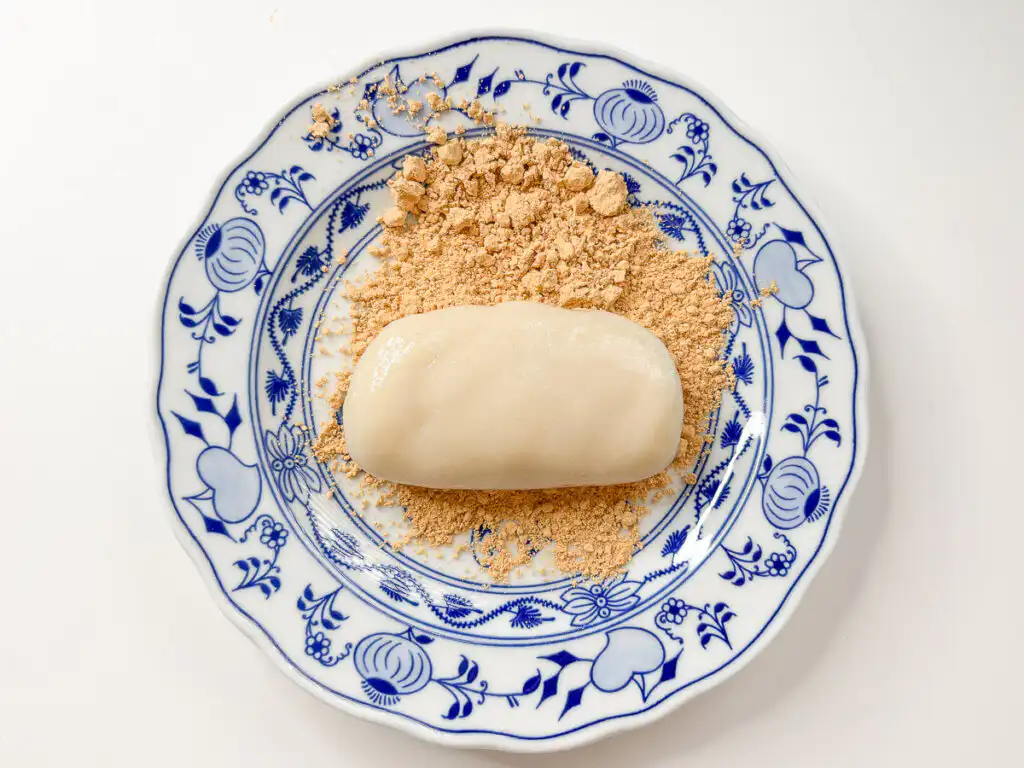 5 Min Microwave Injeolmi: Quick Korean Sweet Rice Cake Placing the hot rectangular rice cake dough directly onto the bed of soybean powder.