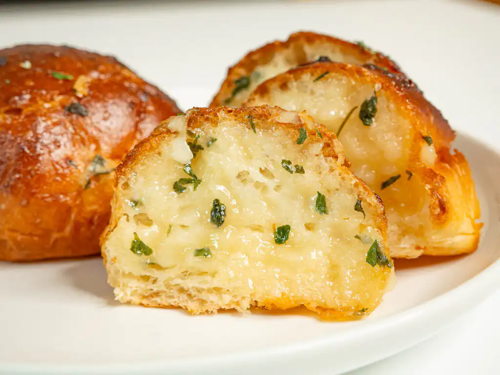 Korean Sweet Garlic Bread with Dinner Rolls: No Cream Cheese, Air Fryer Pulling apart a piece of Korean garlic bread to show the soft inside