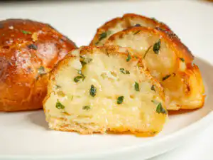 Korean Sweet Garlic Bread with Dinner Rolls: No Cream Cheese, Air Fryer Pulling apart a piece of Korean garlic bread to show the soft inside