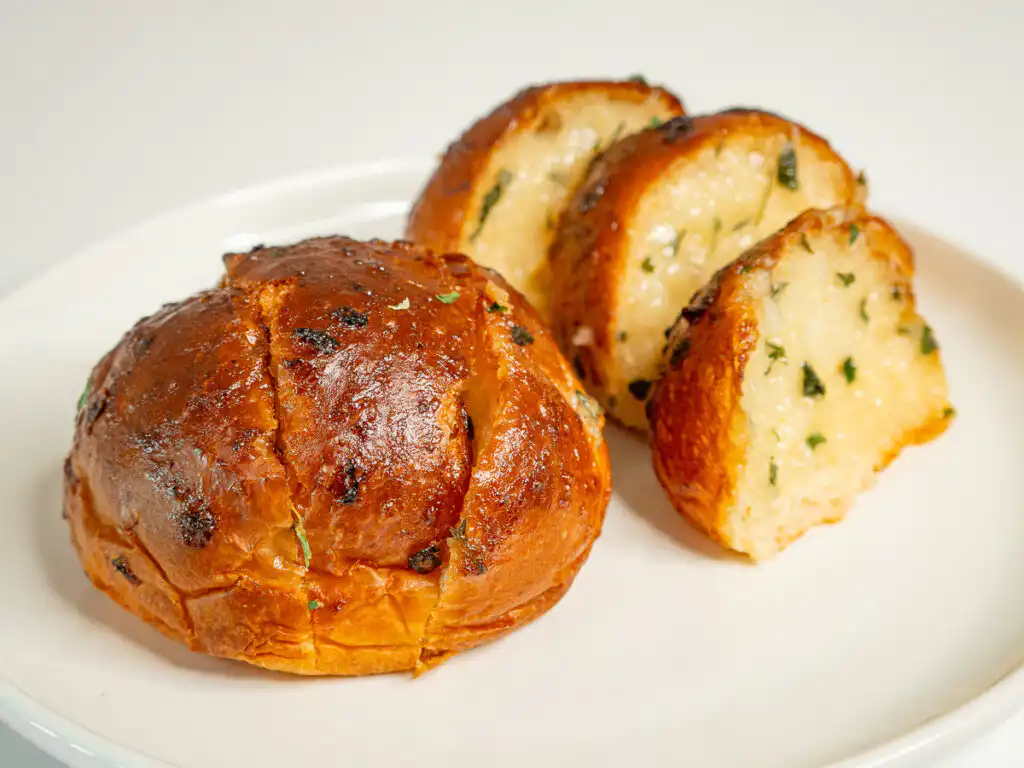 Korean Sweet Garlic Bread with Dinner Rolls: No Cream Cheese, Air Fryer Side view of Korean garlic bread rolls showing the sauced slits