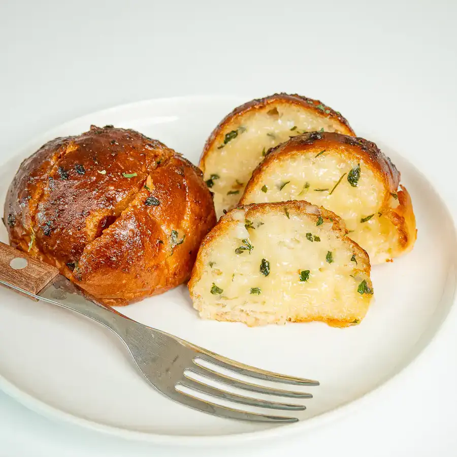 Korean Sweet Garlic Bread with Dinner Rolls: No Cream Cheese, Air Fryer Pulling apart a piece of Korean garlic bread to show the soft inside