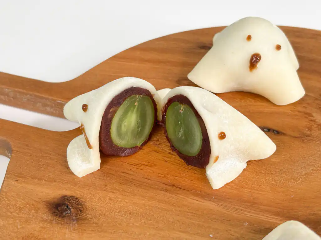 Halloween Ghost Mochi with Shine Muscat, 15-Min Microwave Ghost mochi with a bite showing red bean paste and a Shine Muscat grape