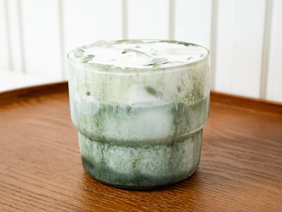 Korean Mugwort Latte: Easy Caffeine-Free Cream Ssuk Latte A Ssuk Latte glass with a straw, showing the cream foam and mugwort gradient