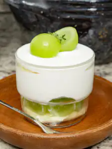 10Min Shine Muscat Cake: Korean Cream Cake with Grape Layered Korean cream cake displaying green fruit slices and cream cheese frosting