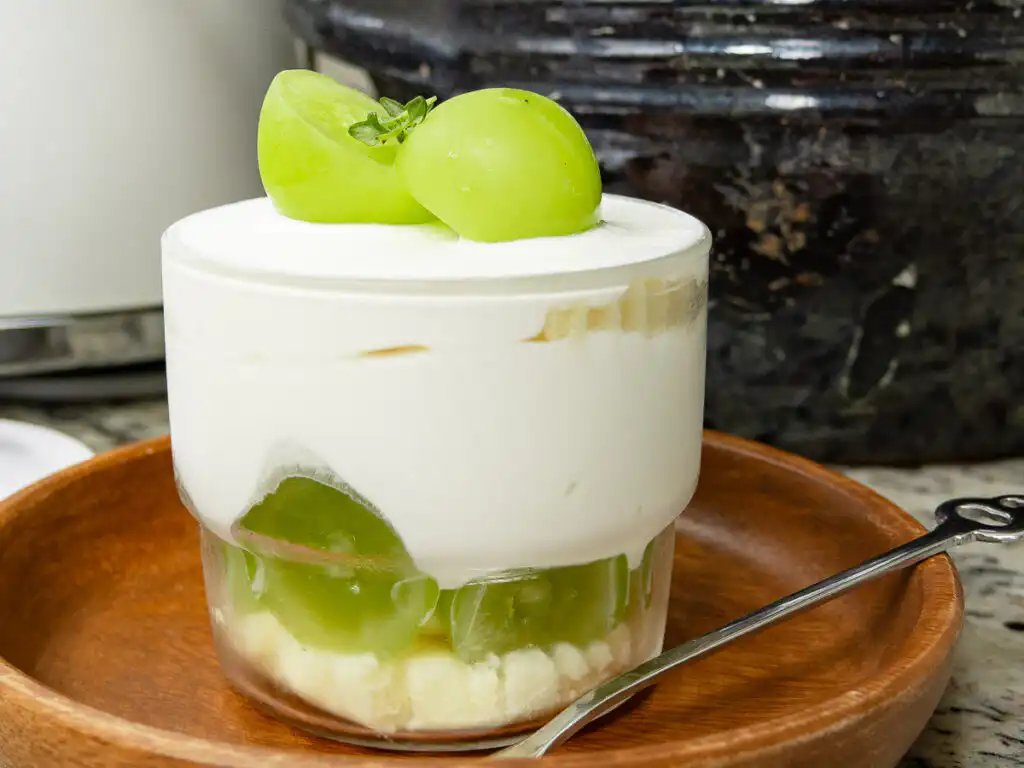 10Min Shine Muscat Cake: Korean Cream Cake with Grape Cross section of asian bakery grape cake filled with whipped heavy cream and fruit
